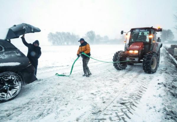 Un agent municipal s'apprête à tracter une voiture piégée par la neige, le 7 janvier 2026 à Sebourg, dans le Nord