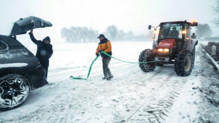 Un agent municipal s'apprête à tracter une voiture piégée par la neige, le 7 janvier 2026 à Sebourg, dans le Nord