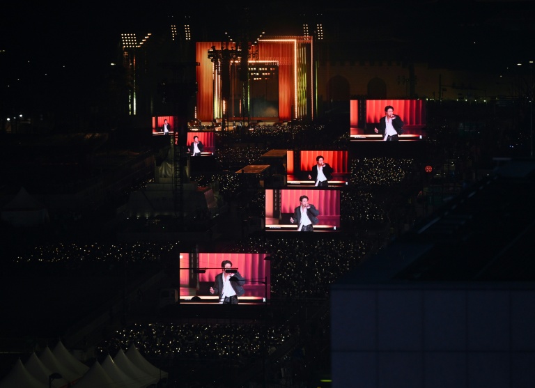 Des fans de BTS regardent le concert marquant le retour du groupe de K-pop sur des écrans installés à Séoul, le 21 mars 2026