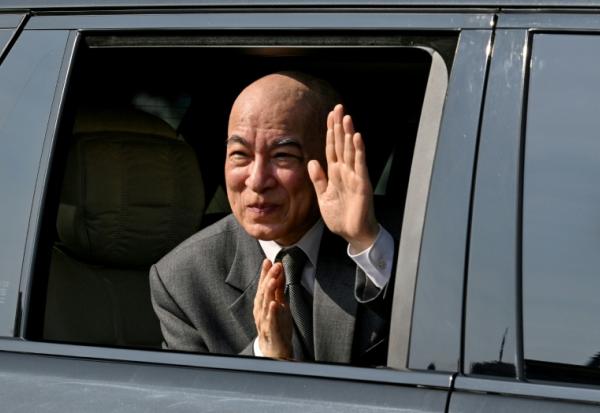 Le roi du Cambodge, Norodom Sihamoni, salue la foule depuis sa voiture lors d'une cérémonie marquant le 72e anniversaire de l'indépendance du Cambodge au Monument de l'Indépendance à Phnom Penh, le 9 novembre 2025