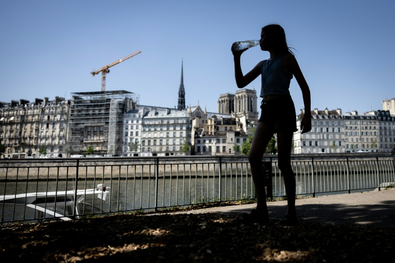 Une jeune femme s'hydrate pendant la canicule, le 24 juin 2026 à Paris