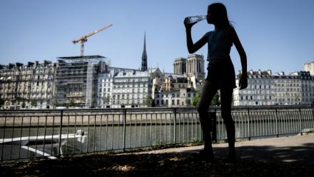 Une jeune femme s'hydrate pendant la canicule, le 24 juin 2026 à Paris