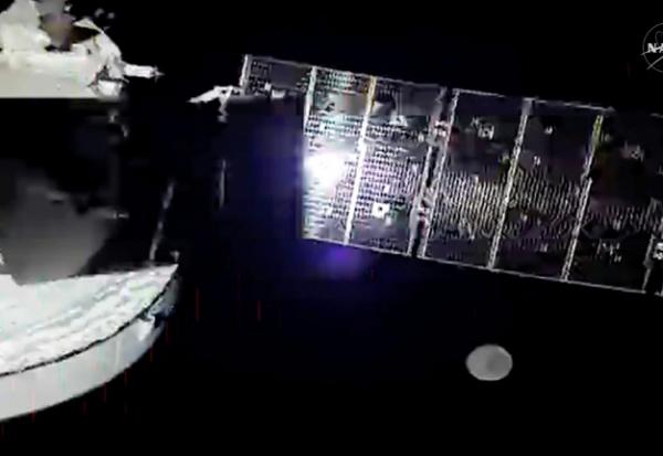 Image tirée d'une diffusion en direct de la Nasa montrant le vaisseau spatial Orion avec l'un de ses quatre panneaux solaires, et la Lune visible en arrière-plan, le 5 avril 2026
