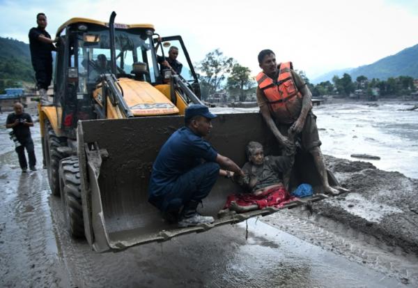 Les secouristes évacuent une personne ayant survécu à la crue soudaine à Devghat, dans le district de Nuwakot au Népal, le 26 août 2026