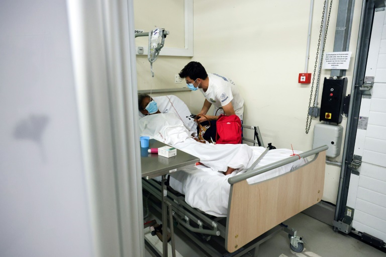 Un médecin s'occupe d'un patient souffrant du chikungunya le 10 avril 2025 à l'hôpital de Saint Paul, à la Réunion