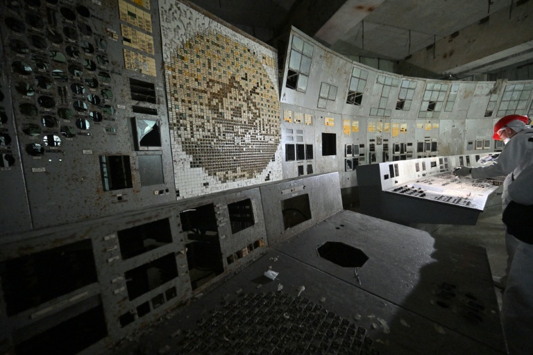 Un visiteur de la centrale nucléaire de Tchernobyl filme dans la salle de contrôle du bloc 4 détruit de la centrale, le 23 avril 2026