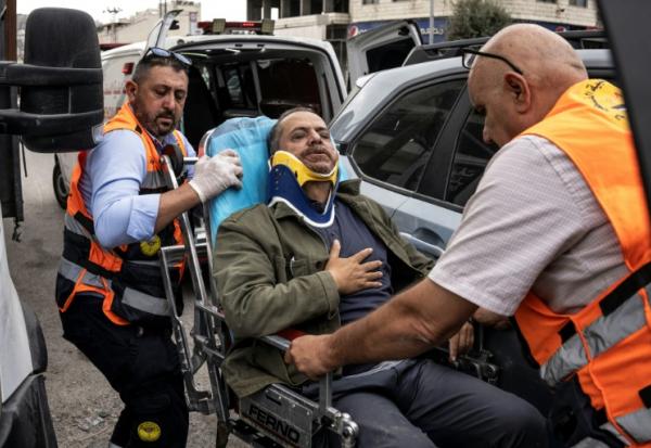 Le photographe palestinien de l'AFP Jaafar Ashtiyeh est évacué par les secours palestiniens après avoir été roué de coups par des colons israéliens à Aqraba, en Cisjordanie occupée, alors qu'il était en reportage, le 6 octobre 2026