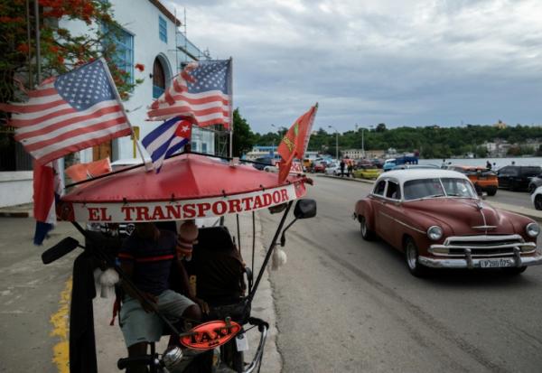 Un tricyle-taxi orné de drapeaux américains, dans une rue de La Havane, le 19 juin 2026 à Cuba