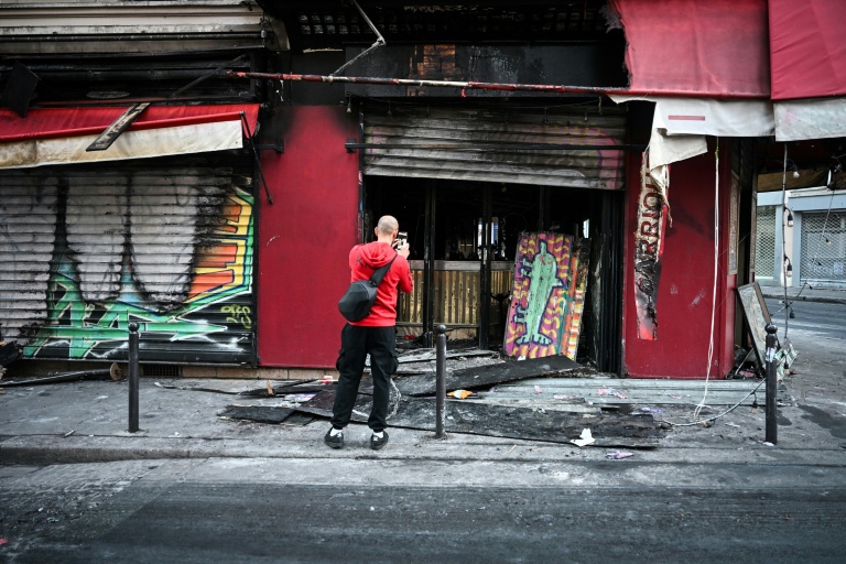 Un passant en prend photo la façade du restaurant 