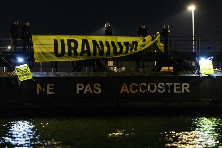 Des policiers retirent une banderole acrochée par des militants de Greenpeace le 2 mars 2026 dans le port de Dunkerque