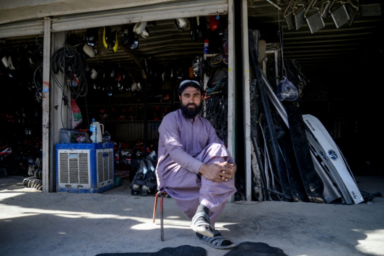 Un homme assis devant un magasin de pièces automobiles, dans un marché situé près d'un poste-frontière entre l'Afghanistan et le Pakistan, dans le district de Spin Boldak, le 29 décembre 2025