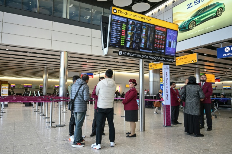 Des passagers devant le comptoir d'enregistrement fermé de la compagnie aérienne Qatar Airways, le 1er mars 2026 à l'aéroport Heathrow de Londres 