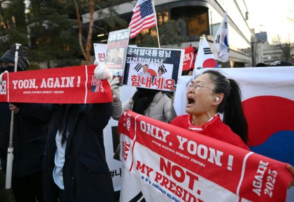 Des partisans de l'ancien président sud-coréen destitué, Yoon Suk Yeol, rassemblés devant le tribunal du district central de Séoul où doit se tenir son dernier procès pénal pour insurrection, le 13 janvier 2026