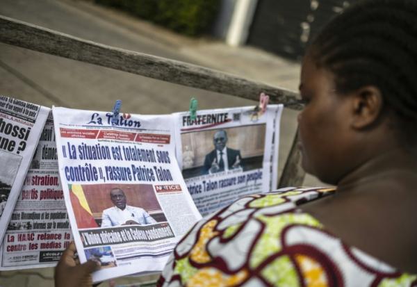 Une habitante regarde les journaux sur un étal dans une rue de Cotonou après une tentative déjouée de coup d'Etat au Bénin, le 8 décembre 2025