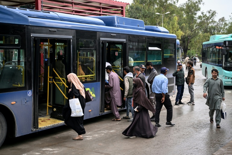 Des passagers montent à bord d'un bus gouvernemental à un arrêt de bus à Islamabad, le 3 avril 2026