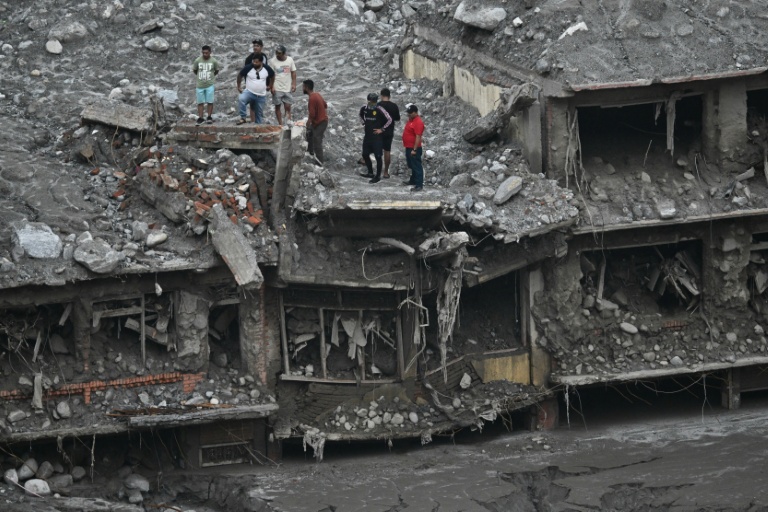 Des habitants sur le toit de maisons endommagées et couvertes de boue au lendemain de crues soudaines à Trishuli, dans le district de Nuwakot, le 6 septembre 2026 au Népal