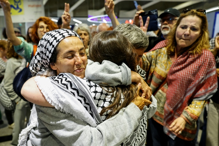 La militante française Meriem Hadjal (G), interpellée puis expulsée par Israël après l'interception de la flottille à destination de Gaza, embrasse un proche à son arrivée à l'aéroport de Roissy-Charles-de-Gaulle, près de Paris, le 22 mai 2026