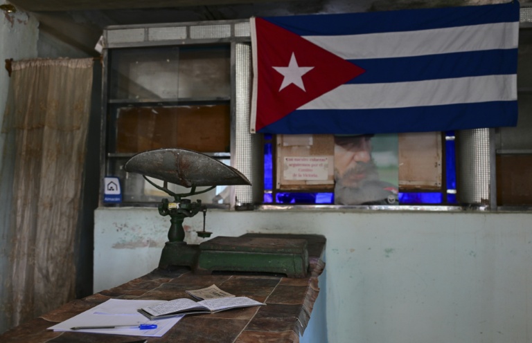 Une vieille balance sur le comptoir d'une épicerie à prix subventionnés, près d'un drapeau cubain et d'un portrait de Fidel Castro (1959-2006), le 5 octobre 2026 à La Havane, à Cuba