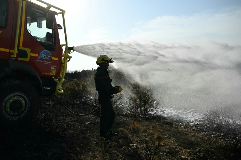 Des pompiers éteignent des cendres chaudes à côté d'Albas, dans le massif des Corbières, le 9 août 2025