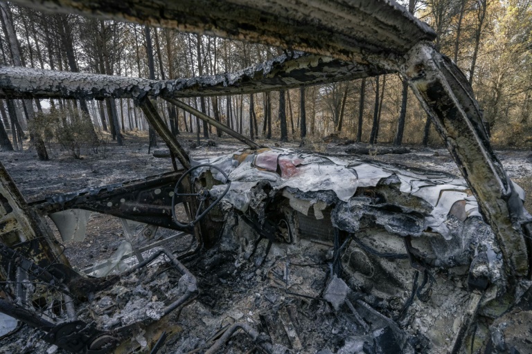 Une voiture calcinée dans une forêt après l'incendie dans l'Aude, le 9 août 2025, à Fontjoncouse