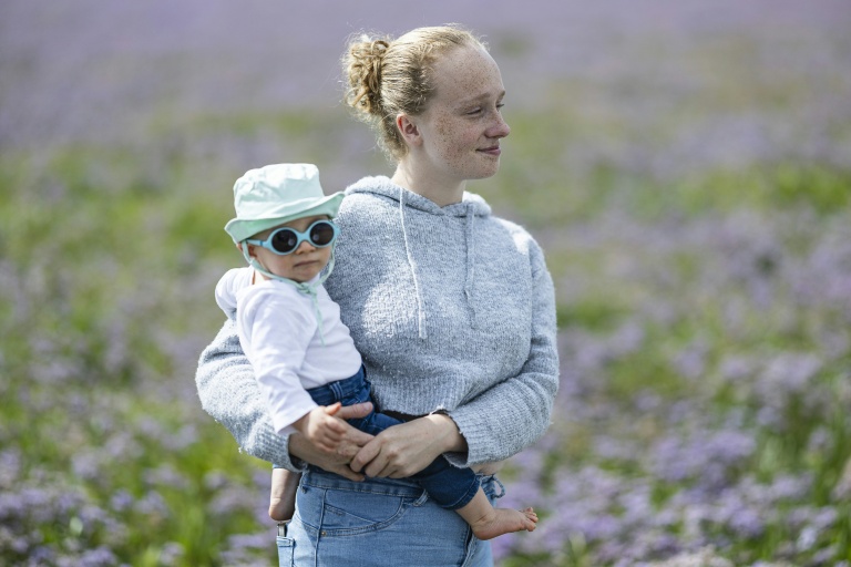 Lou-Anne pose avec son bébé de 11 mois au Crotoy, dans la baie de Somme, le 30 juillet 2025