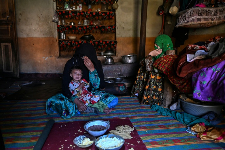 L'agricultrice Habiba (g) prend le petit déjeuner avec sa fille Zuheida (d) et sa petite-fille Saeeda dans le village d'Eshtiwi, au Nouristan, le 8 juin 2026 en Afghanistan