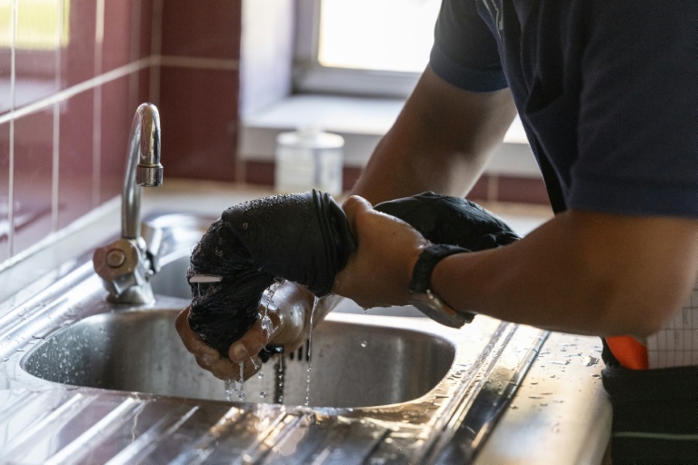 Avant son utilisation, le gilet rafraîchissant doit être immergé dans l'eau fraîche et essoré, le 12 août 2025 à Châtillon, au sud de Paris