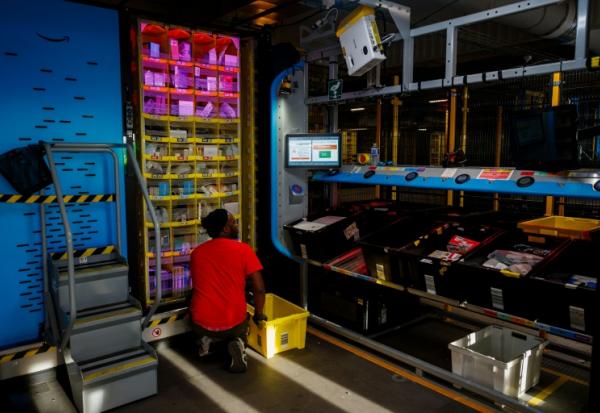 Un salarié d'Amazon s'occupe de paquets dans l'entrepôt de l'entreprise à Brétigny-sur-Orge, en Essonne, le 22 novembre 2023