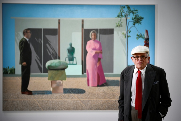 David Hockney pose devant sa peinture 