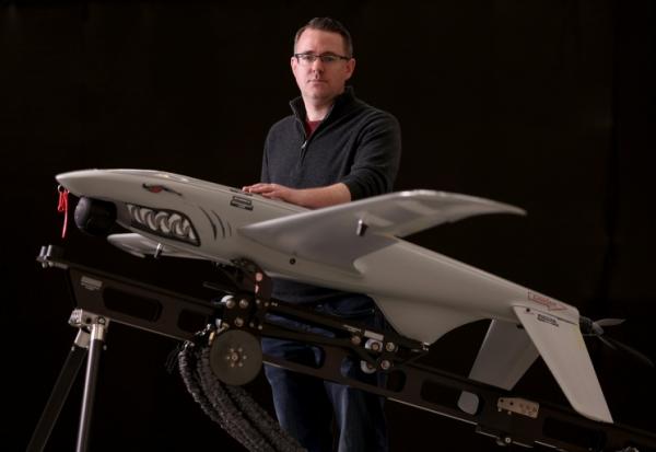 Le directeur général d'Ukrspecsystems, Rory Chamberlain, à côté d'un des drones de reconnaissance Shark dans l'usine britannique de l'entreprise près de Cambridge, dans l'est de l'Angleterre, le 5 mars 2026