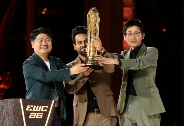 Le dirigeant de l'équipe chinoise All Gamers Le Kedeng (à gauche) brandit le trophée de l'Esports World Cup à Paris le 23 août 2026

