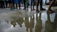 Des électeurs font la queue devant un bureau de vote pour les élections législatives au Suriname, à Paramaribo, le 25 mai 2025