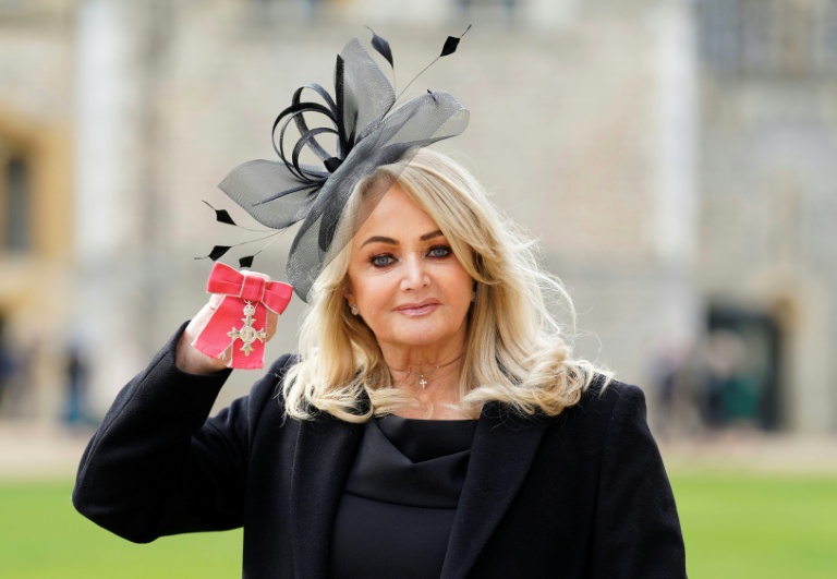 La chanteuse britannique Bonnie Tyler montre sa médaille après avoir été nommée membre de l'ordre de l'Empire britannique (MBE) lors d'une cérémonie au château de Windsor, le 1er février 2023