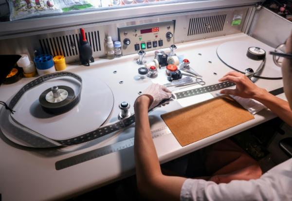 Un technicien inspecte la pellicule d'un vieux film à l'Institut taïwanais du cinéma et de l'audiovisuel (TFAI), le 23 juin 2026 à Taipeï

