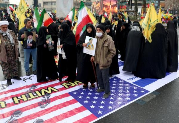 Photo réalisée avec l'accord du ministère de la Culture et de l'Orientation islamique iranien d'Iraniens qui marchent sur un drapeau américain lors d'une commémoration en soutien au peuple palestinien, à Téhéran, le 13 mars 2026