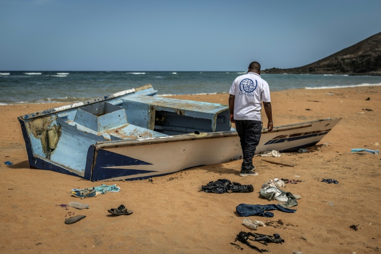 Un membre de l'Organisation internationale pour les Migrations (OIM), sur la plage de Gehere à Djibouti, près des restes d'une embarcation transportant des migrants et ayant fait récemment naufrage
