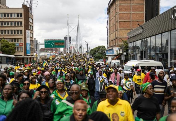 Des milliers de manifestants, appelés à défiler par l'ANC, traversent l'emblématique pont Nelson Mandela de Johannesburg le 21 mars 2026.