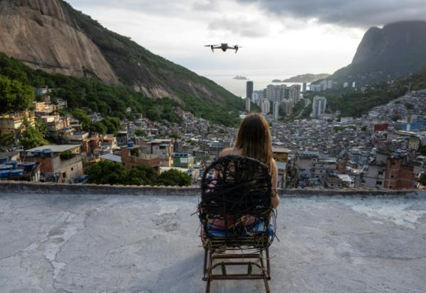 Une touriste se fait filmer par un drone sur le toit d'une maison dans la favela de Rocinha, à Rio de Janeiro, au Brésil, le 5 mars 2026