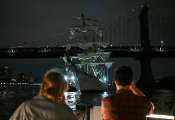 Des personnes regardent un navire-école de la marine mexicaine après qu'il a heurté le pont de Brooklyn à New York, le 17 mai 2025