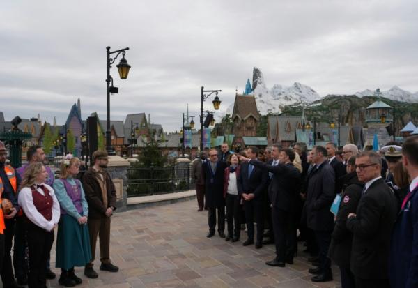 Le président Emmanuel Macron (au centre) à l'inauguration du nouveau parc à thème « Le Monde de La Reine des neiges » à Disneyland Paris, à Marne-la-Vallée, à l'est de Paris, le 27 mars 2026.