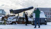 Une femme pose sur fond d'un drone russe Shahed abattu et exposé à Kiev, le 17 février 2026 