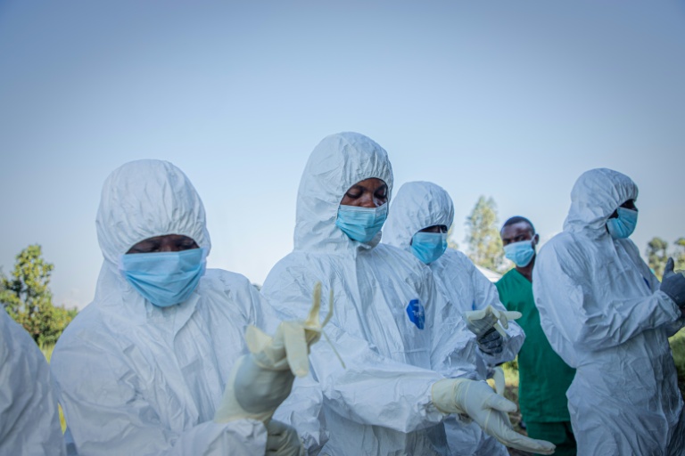 Des volontaires enfilent leurs équipements de protection avant de récupérer le corps d'un enfant de 3 ans, présumé mort du virus Ebola, le 11 juin 2026 à Bunia, en RDC 