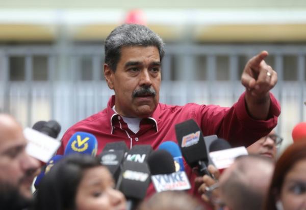 Cette photo fournie par la présidence vénézuélienne montre le président vénézuélien Nicolas Maduro s'adressant à la presse devant un bureau de vote lors des élections régionales, à Caracas, le 25 mai 2025