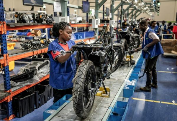 Assemblage de motos électriques sur une chaîne de montage au centre de production de Spiro, la plus grande entreprise de véhicules électriques d'Afrique, le 22 mai 2026 à Nairobi, au Kenya