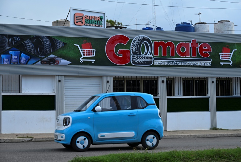Une voiture électrique passe devant un magasin privé à La Havane, le 22 juin 2026 à Cuba