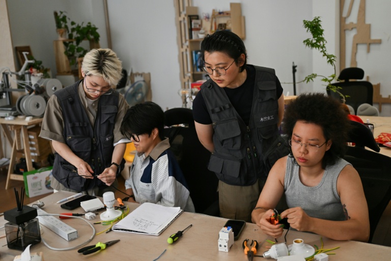 Les formatrices Wu Shuang (c) et Wang Risun (g) donnent un cours d'électricité à des participantes de l'atelier Mulan Build à Hangzhou, dans la province du Zhejiang, le 28 juin 2026 dans l'est de la Chine