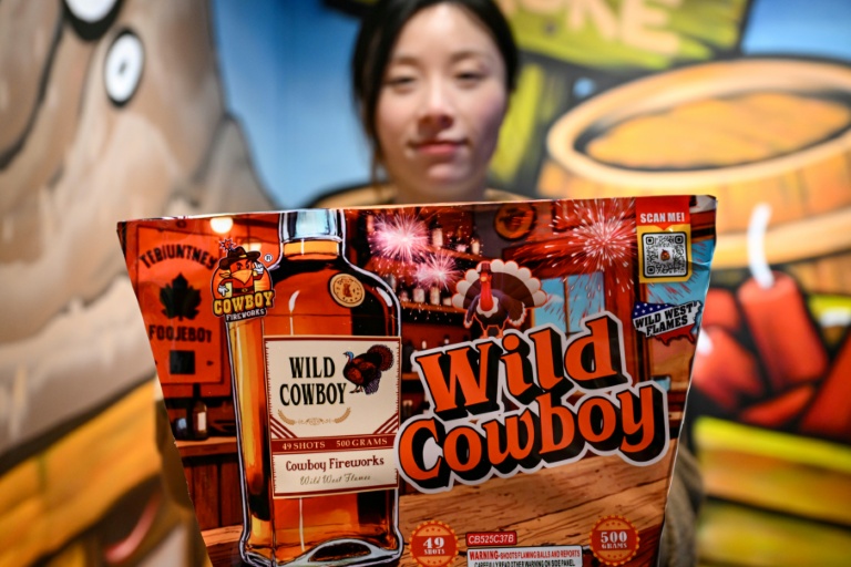 Une employée montre un paquet de feux d'artifice destinés au marché américain dans une galerie du groupe Zhongzhou Fireworks, à Liuyang, dans la province du Hunan, le 21 janvier 2026 en Chine