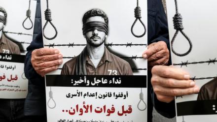 Des manifestants brandissent des pancartes sur lesquelles on peut lire "Appel urgent et final : arrêtez l'application de la loi sur les prisonniers avant qu'il ne soit trop tard" devant les locaux de la Croix-Rouge à Ramallah, en Cisjordanie occupée par Israël, le 31 mars 2026