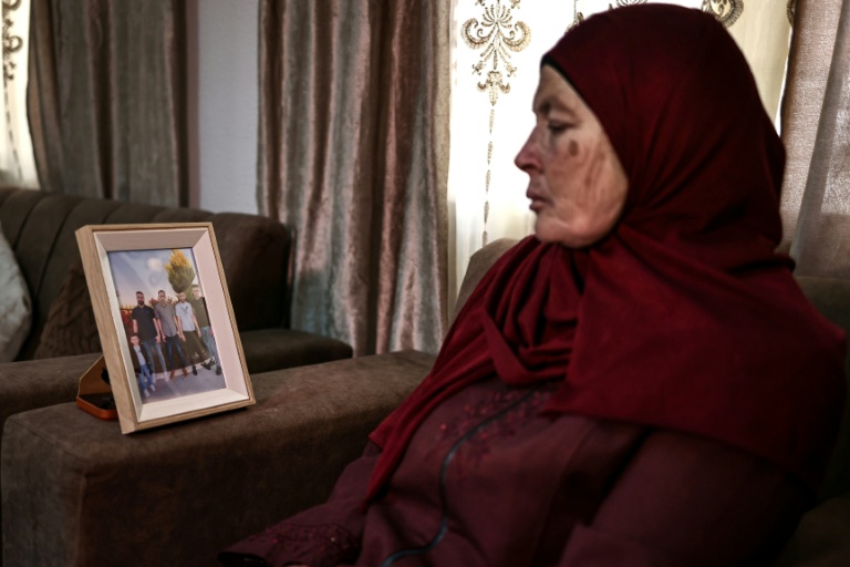 Milia Hamayel, dont le fils Thaer Hamayel a été tué lors d'une attaque de colons israéliens, regarde une photo de son fils défunt dans son village de Abou Falah, au nord-est de Ramallah, le 12 mars 2026