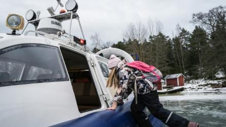 Une écolière embarque à bord d'un aéroglisseur pour rentrer de l'école, le 3 mars 2026 à Paragas, en Finlande
